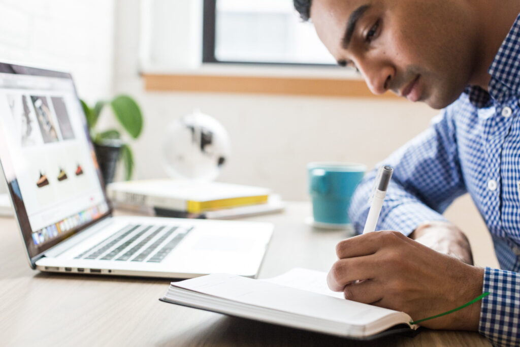 A man studying on a table with a laptop in front of him