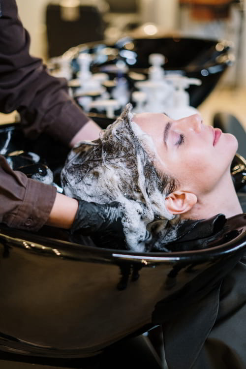 Woman getting shampoo done in a salon